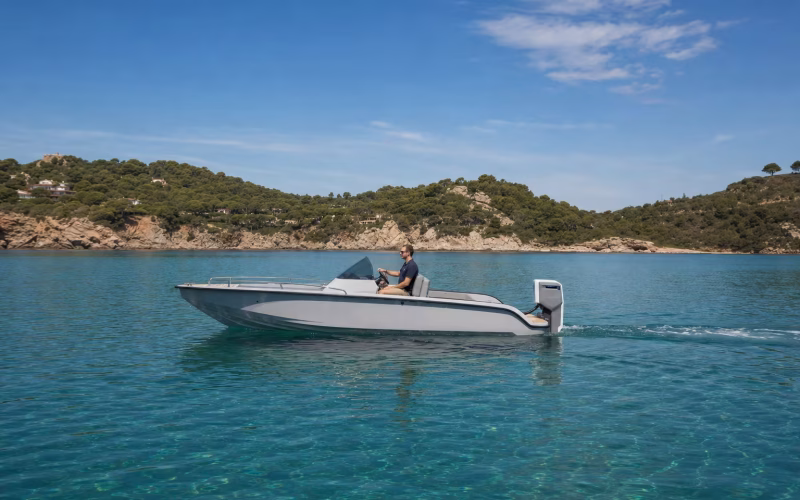 Modernes Motorboot mit Elektro-Außenborder gleitet leise über klares Wasser vor einer Küste