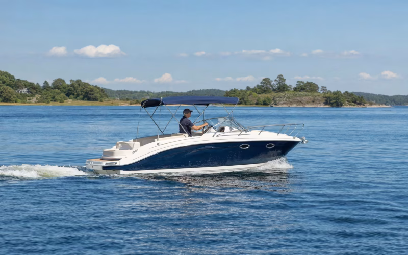 Motorboot gleitet sparsam bei moderater Fahrt über ruhiges Wasser vor einer Küste