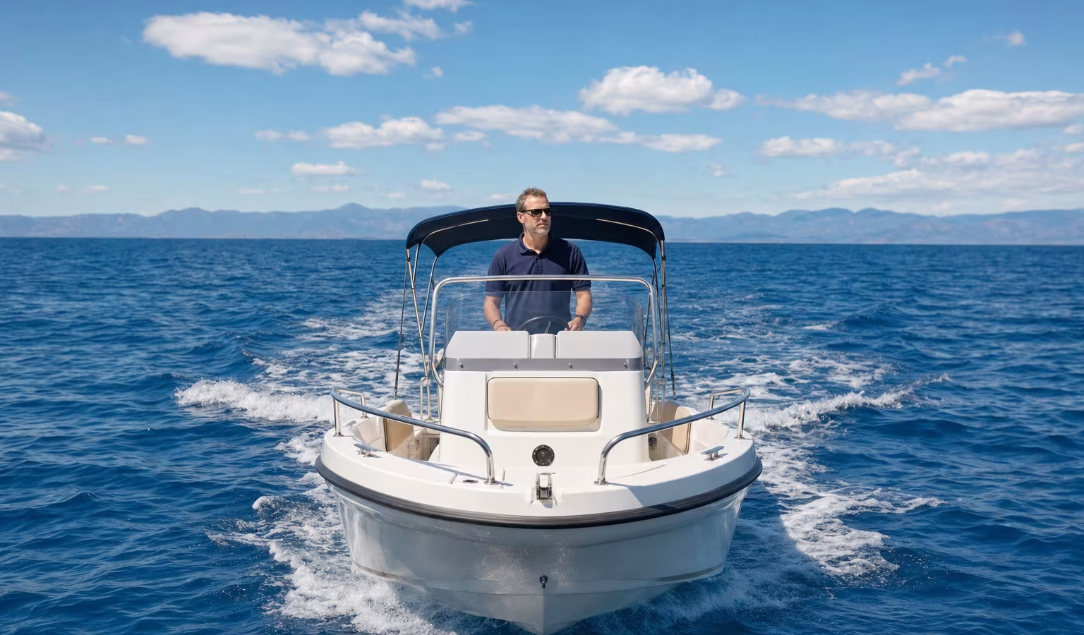 Konzentrierter Skipper steuert ein Motorboot mit beiden Händen am Steuerrad bei klarer Sicht