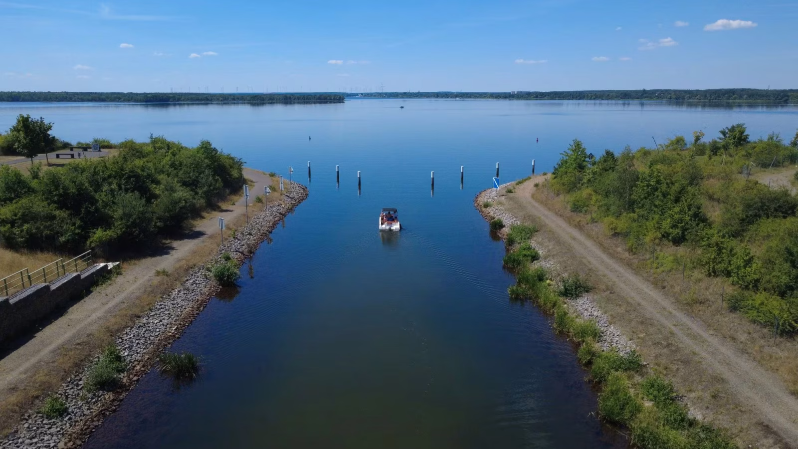 Motorboot faehrt durch den Koschener Kanal in den Senftenberger See im Lausitzer Seenland