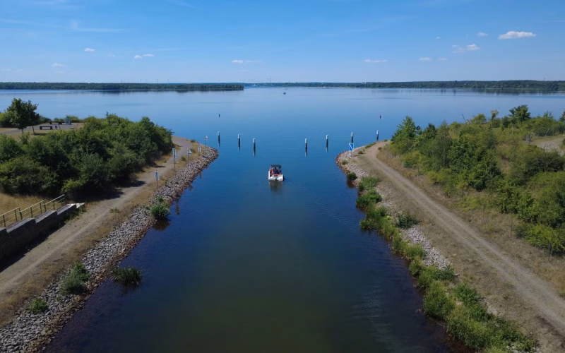 Motorboot faehrt durch den Koschener Kanal in den Senftenberger See im Lausitzer Seenland