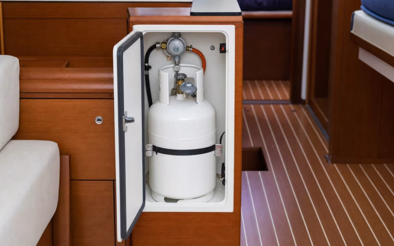 Geöffneter Gasflaschenkasten mit Propanflasche und Druckregler auf einer Yacht